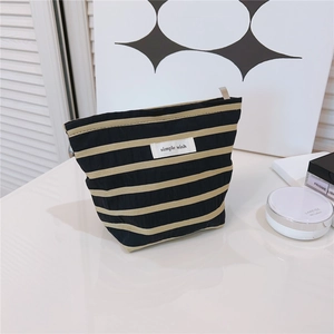 Close-up of striped canvas cosmetic bag with zipper and Simple Wish logo on fabric