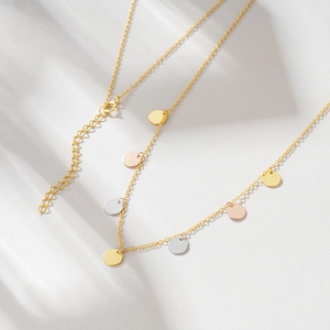 Detail of s925 silver necklace featuring shiny tricolor geometric discs in soft light