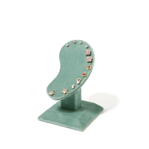 Green velvet display stand featuring a variety of gold stud earrings with pearls and crystals