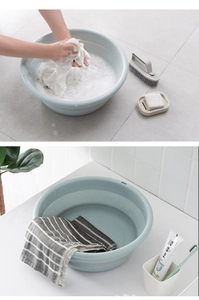 Detail of light green foldable washbasin in a bathroom setting showing compact storage