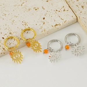 Elegant gold and silver hoop earrings with evil eye charms and orange beads on stone