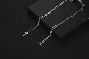 Close-up of titanium steel cross necklace with asymmetrical chains and T-bar clasp