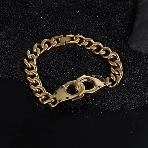 Detailed macro shot of gold Cuban link chain with a polished handcuff clasp on black sand
