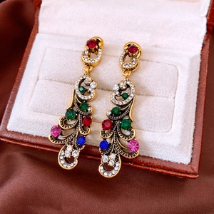 Close-up of vintage geometric earrings with colorful rhinestones in a luxury jewelry box