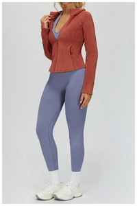 Slim fit brick red fleece zip hoodie and blue yoga leggings shown on a model outdoors