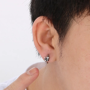 Close-up of vintage skull hoop earring in silver steel finish worn on a male ear