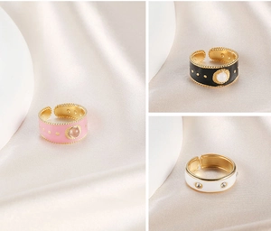 Detail of colorful enamel adjustable rings with gemstones on soft silk background