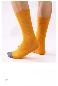 Détail de chaussettes en coton jaune montrant la texture côtelée et le bout gris
