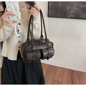 Detail view of dark brown oil wax leather Boston bag with retro buckle pockets