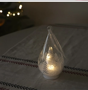 Teardrop glass Christmas ornament with miniature tree and warm LED lights inside