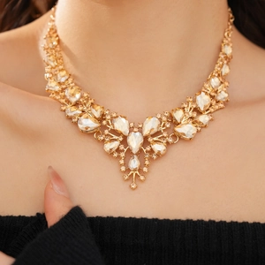 Close-up of a luxury gold-tone V-shaped necklace with champagne crystals on a model