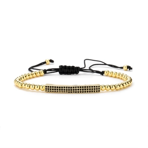 Bracelet à perles dorées réglable avec barre sertie de zircons noirs sur fond blanc