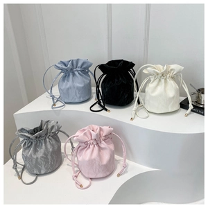Minimalist drawstring bucket bags shown in five pastel colors with elegant pleated texture