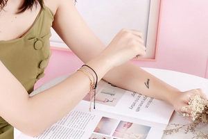 Adjustable snake chain bracelets in gold silver and black shown on a woman wrist