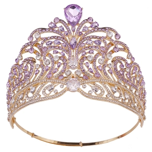 Close-up of golden crown with purple teardrop gems and white crystal rhinestones