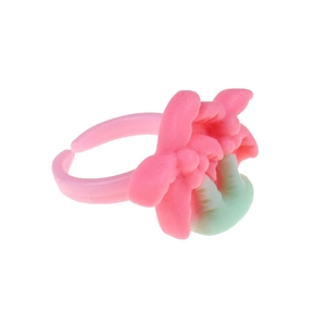 Detailed macro view of pink plastic flower ring for girls with mint green accents