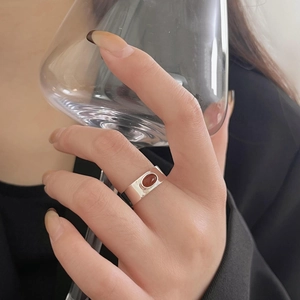 Detail view of a 925 sterling silver ring with oval carnelian stone on model's hand