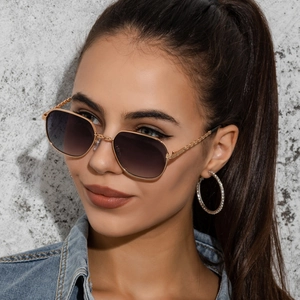 Detail of square gold metal sunglasses with gradient lenses worn by a model