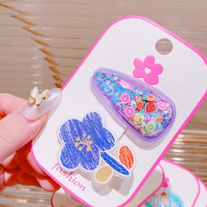 Detailed view of kids fruit snap clip and flower hairpins on a fashion display card
