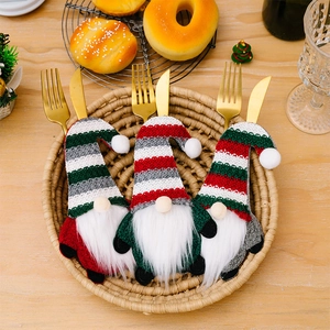 Three striped gnome cutlery holders for Christmas table setting displayed in a woven basket