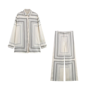Flat lay of satin long-sleeve shirt and wide-leg trousers with black geometric patterns
