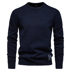 Détail du pull en maille bleu marine montrant la texture et l'étiquette de taille S