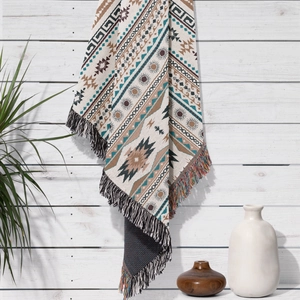 Detail of bohemian woven blanket with ethnic geometric patterns and colorful tassels