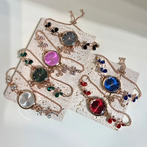 Macro shot of stylish bracelet watches with butterfly accents and colorful gemstones