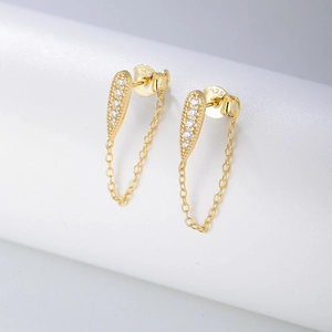Detail of S925 silver chain tassel earrings with gold finish and white zircon stones
