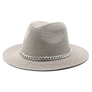 Detail of light khaki straw Panama hat with wide brim and decorative silver chain link