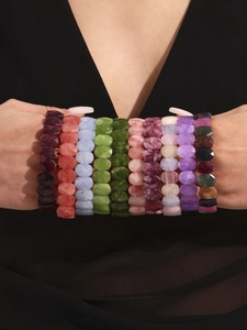 Gros plan de bracelets élastiques en pierres naturelles facettées colorées sur un poignet