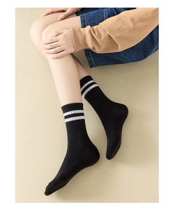 Close-up of black cotton crew socks with double white stripes for a sporty athletic look