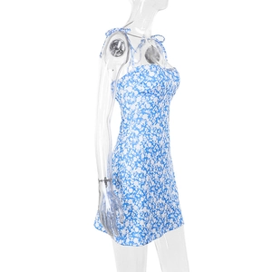 Detail view of blue floral mini dress featuring spaghetti straps and pleated bust design