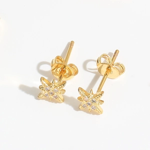 Macro shot of gold-plated star stud earrings featuring centered white zircon stones