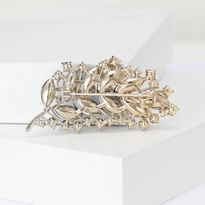 Detailed back view of golden alloy feather brooch showing clasp and hollow structure