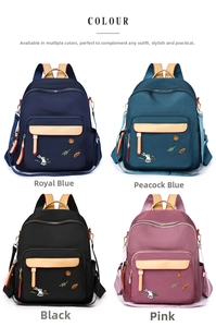 Detail view of multi-pocket backpack showing navy blue, peacock blue, black, and pink colors