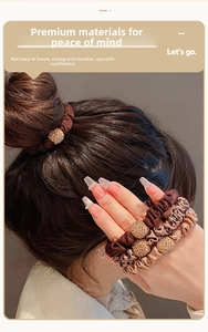 Detail of satin scrunchie with golden rhinestone ball ornament in earth tones
