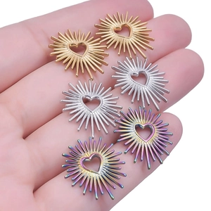 Macro view of heart sunburst earrings in gold, silver, and rainbow steel finishes