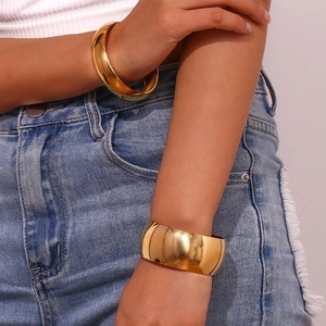 Polished 18K gold plated stainless steel stacked bangles on model's wrist detail
