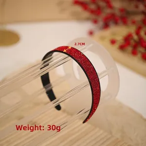Red rhinestone headband with 2.7cm width and 30g weight on a display stand