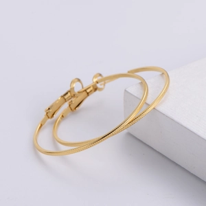 Textured 18k gold plated hoop earrings with knurled cross pattern on white pedestal