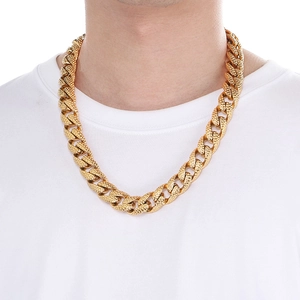 Close-up of a chunky gold Cuban link chain necklace worn on a white t-shirt