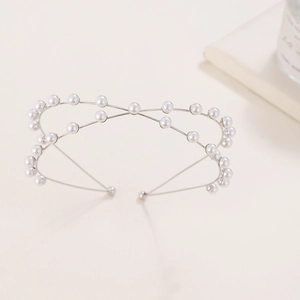 Detail of silver double-layered metal headband with elegant white pearls on a soft background