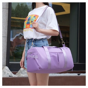 Outdoor view of a purple waterproof fitness bag with wet dry separation and shoulder strap