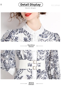 Detail des weißen Spitzenkleids mit blauen Blumenmustern und weißem Ledergürtel