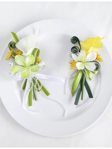 Close-up of calla lily boutonnieres with delicate pearls and green ribbon detail