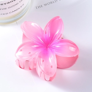 Detail of pink plumeria flower hair claw clip with gradient resin petals and metal spring