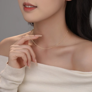 Minimalist S925 sterling silver beaded necklace in gold worn by a female model