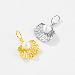 Detail of s925 silver shell-shaped pendants with central pearl in gold and silver finishes