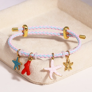 Detail of adjustable woven bracelet with blue starfish and coral charms in a jewelry box